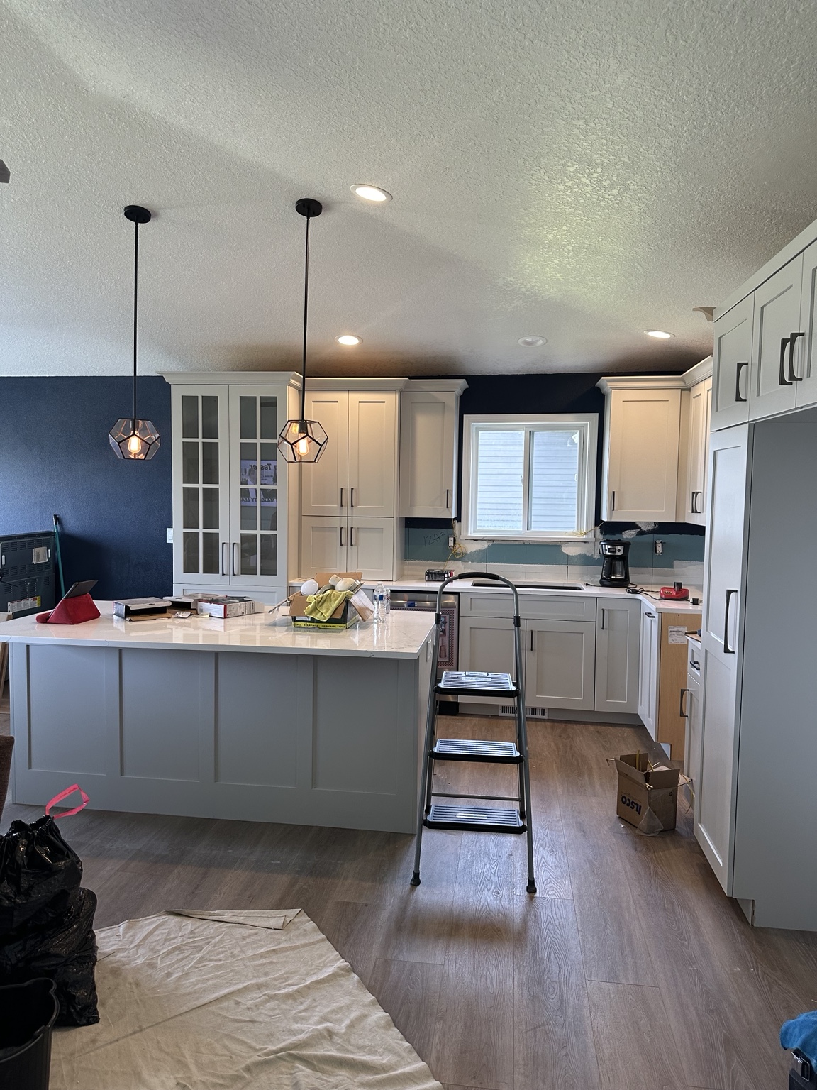 Kitchen with two pendant lights over an island and recessed ceiling lights